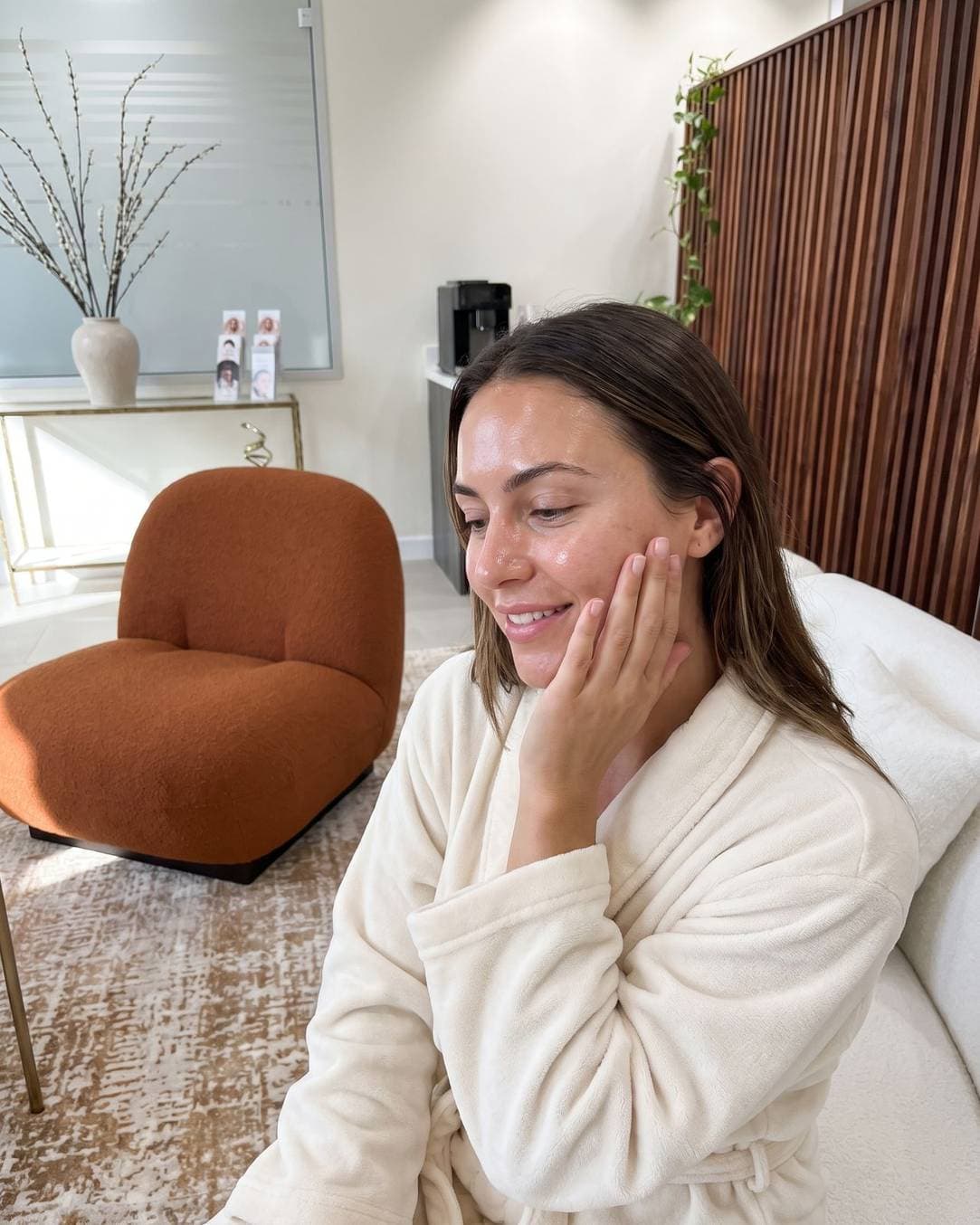 A woman with luminous, dewy skin after a GLACÉ glass skin facial in the lounge