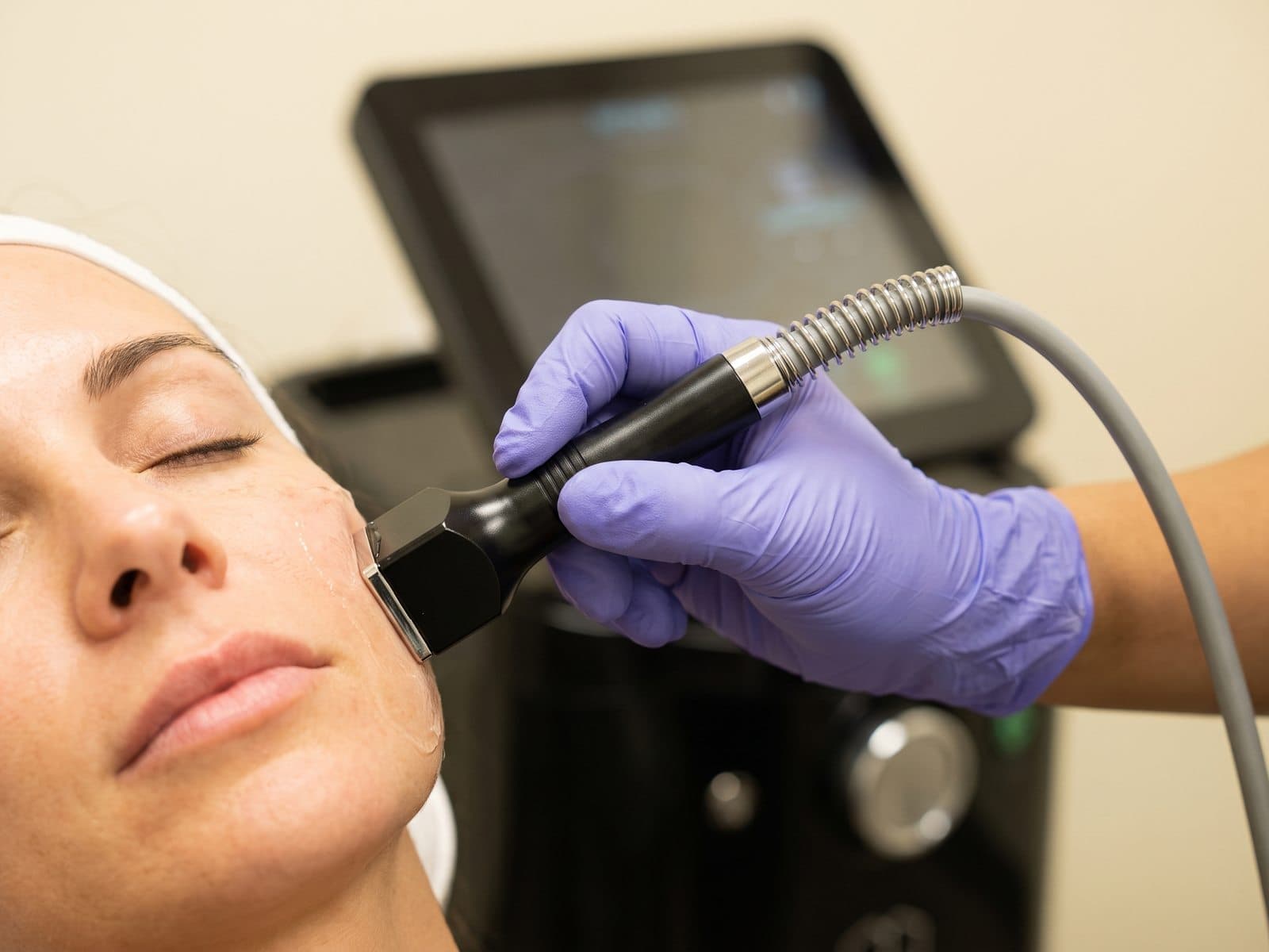 Close view of the Forma radiofrequency handpiece gliding along a cheek