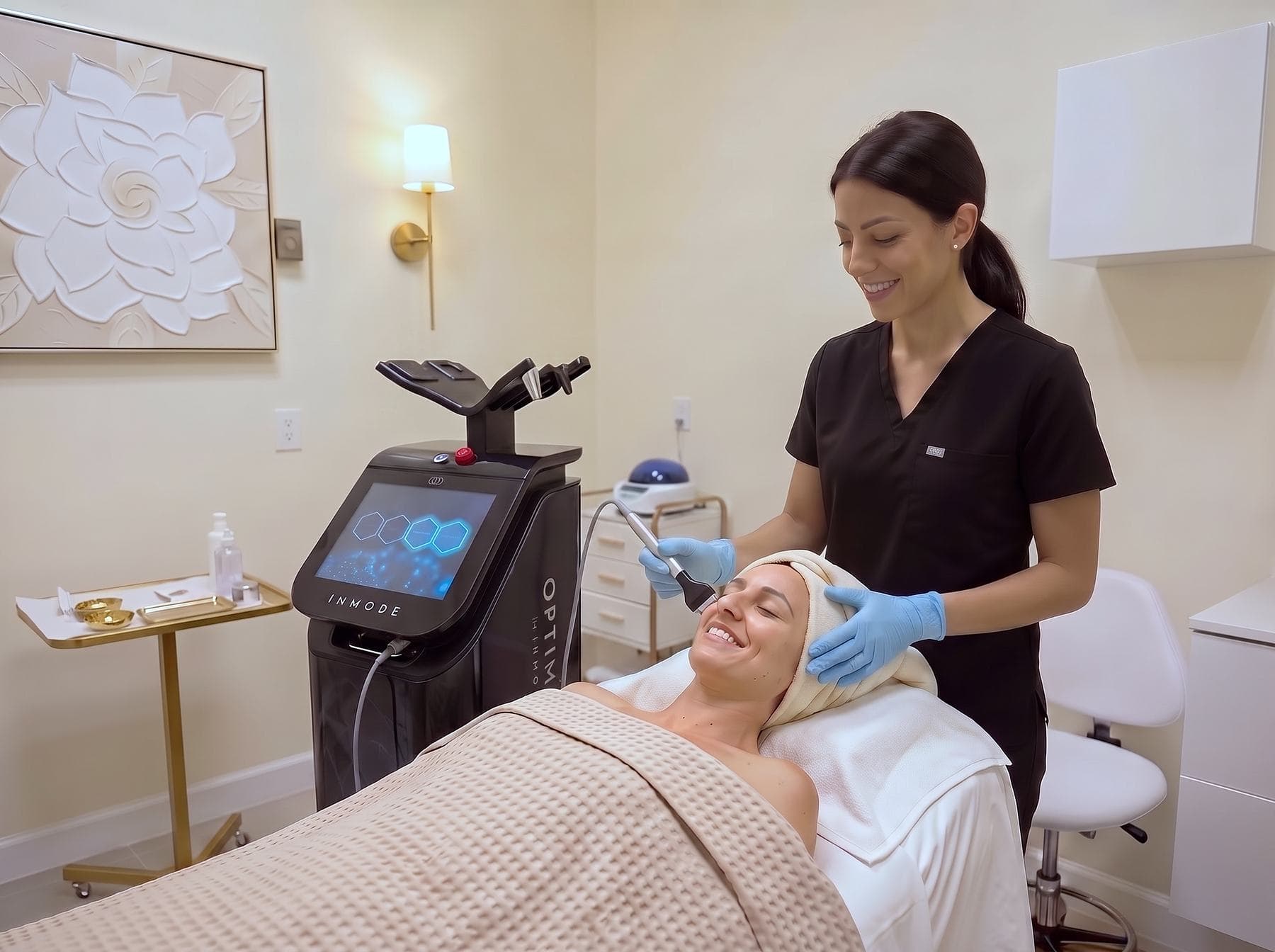 Forma radiofrequency wand gliding along a woman's glowing jawline during the Hollywood Facial at The Body Bar MD