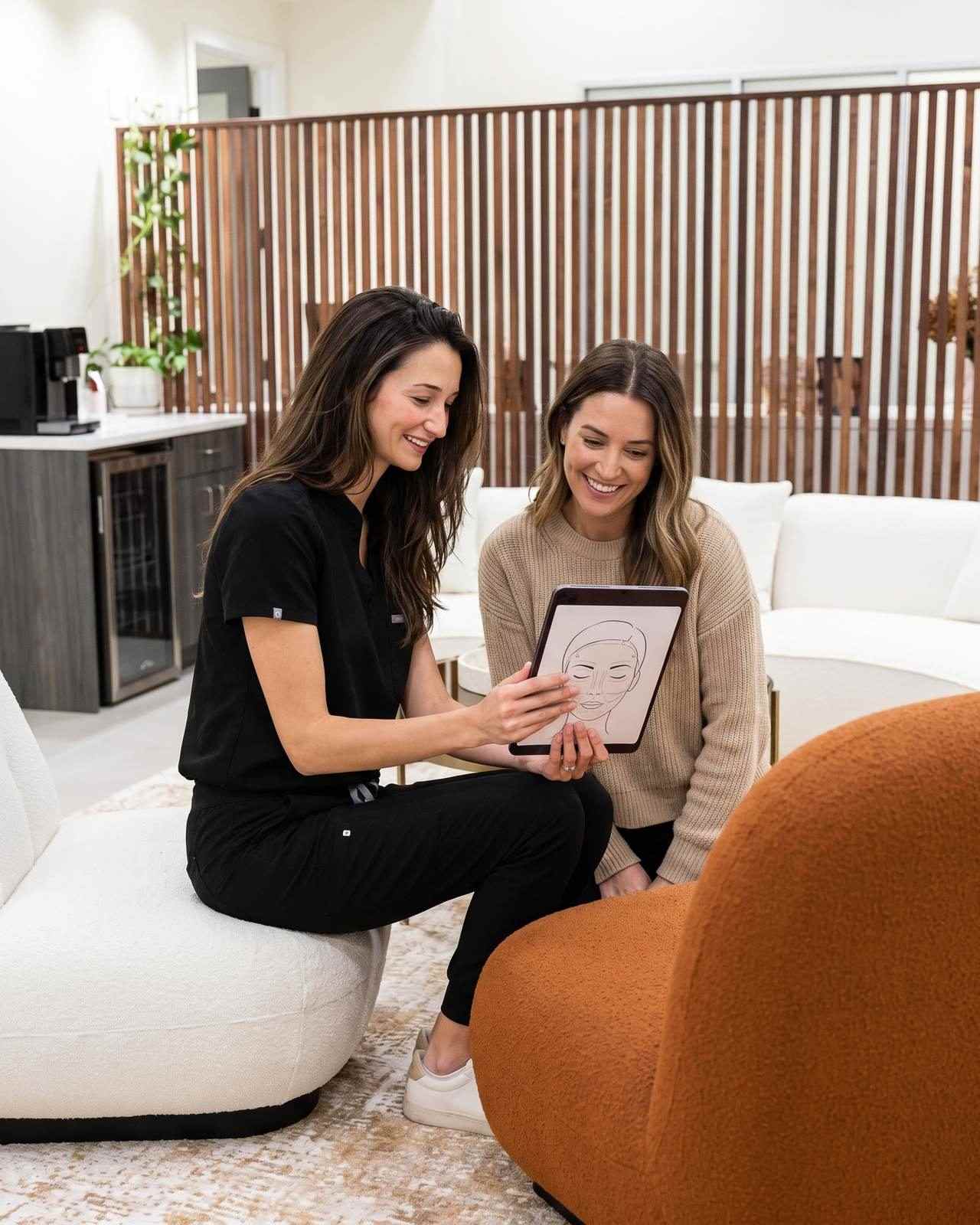 A nurse reviewing a Morpheus8 treatment plan on a tablet with a seated patient