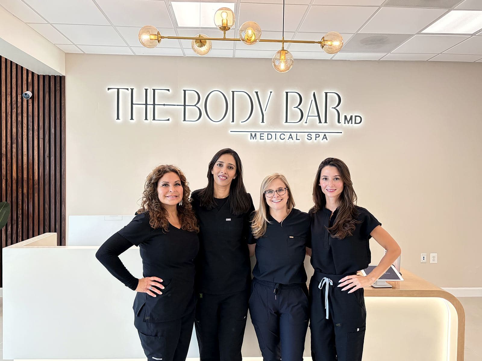 The Body Bar MD team standing together at the reception of their Ellicott City clinic