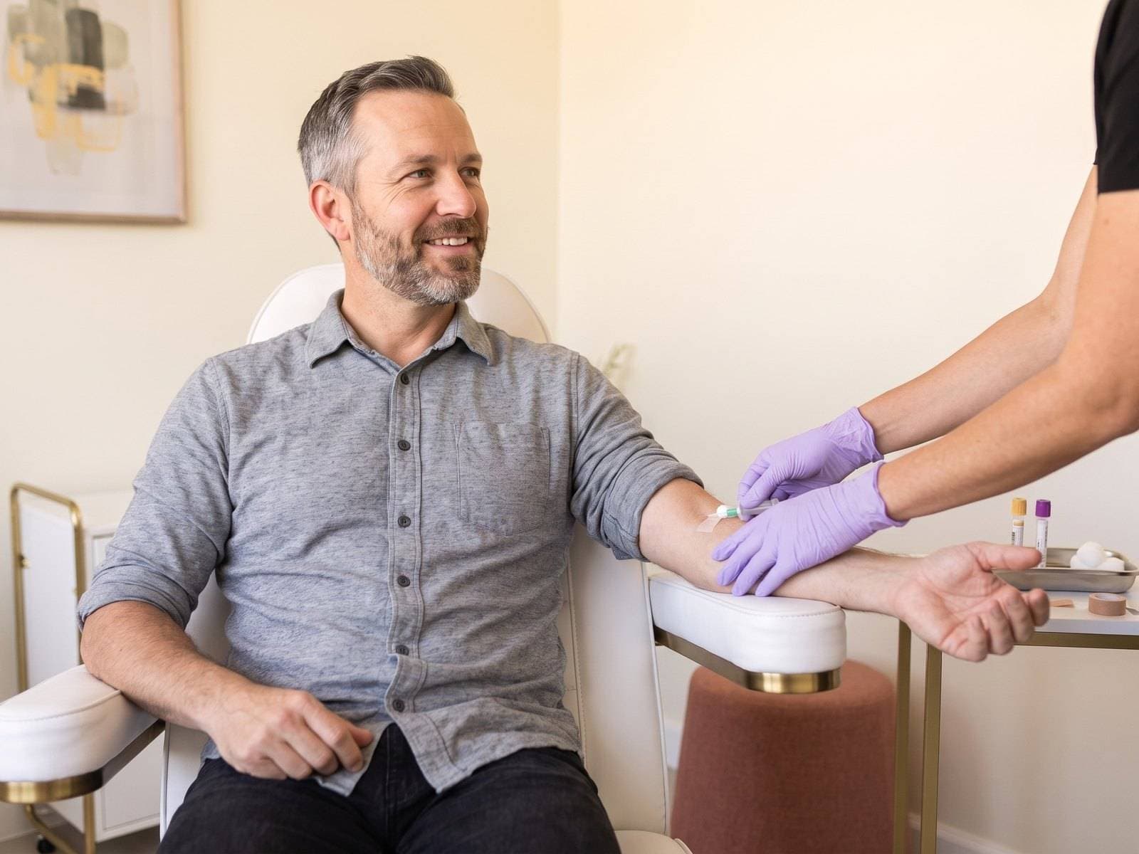 Gloved hands drawing blood into tubes for a TRT hormone lab panel